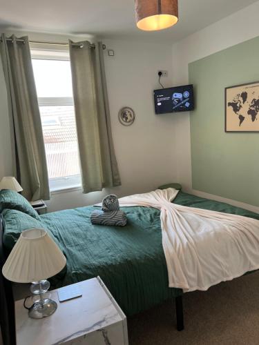 a bedroom with a bed and a table with a lamp at The Big One Blackpool in Blackpool