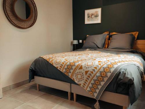 une chambre avec un lit avec un miroir au mur dans l'établissement Charmante maison avec jardin aux portes des gorges de l'Ardèche, à Saint-Julien-de-Peyrolas