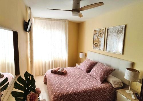 a bedroom with a bed and a ceiling fan at Good Atmosphere Apartment in El Vendrell
