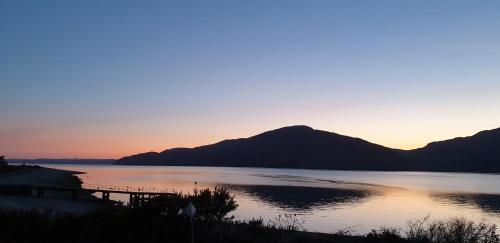 a sunset over a lake with mountains in the background at Tigh na Camus in Glenelg