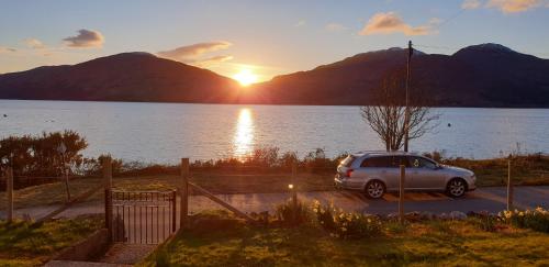 a car parked in a parking lot next to a lake at Tigh na Camus in Glenelg