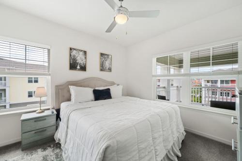 a white bedroom with a bed and two windows at Lavish 2BR Apartment in Tampa in Tampa