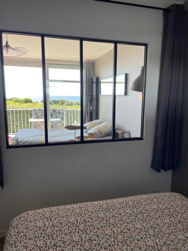 a mirror in a bedroom with a bed and a balcony at Appartement Belles Vacances in Quiberon