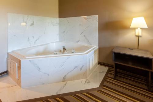a large white tub in a room with a piano at Super 8 by Wyndham La Grange KY in La Grange