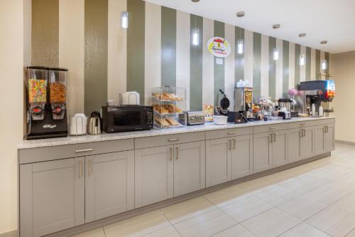 a cafeteria with a counter with aasteryasteryasteryasteryasteryasteryasteryasteryastery at Super 8 by Wyndham La Grange KY in La Grange