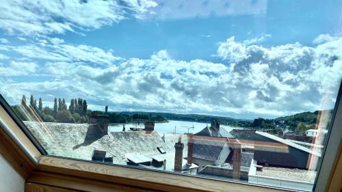 a window with a view of a town at La Seine en couleurs in Duclair