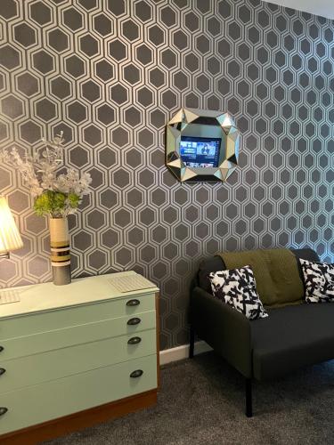 a living room with a chair and a tv on a wall at The Big One Blackpool in Blackpool