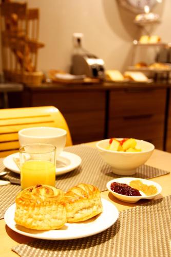 a table with plates of pastries and bowls of fruit at Hotel Le Richemont in Paris