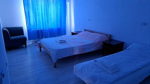 une chambre d'hôtel avec deux lits et une chaise dans l'établissement TC Vest Residence, à Leţcani