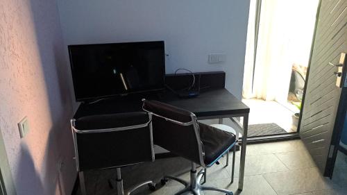 LeţcaniTC Vest Residence的一张桌子,带显示器和椅子