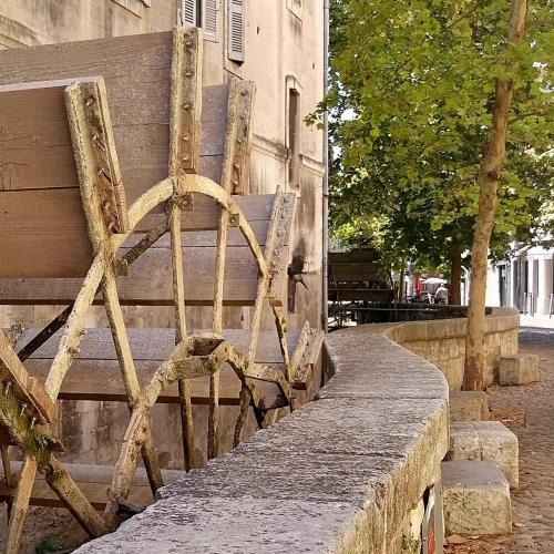 a wooden bench sitting next to a building at Au fil de l'eau in Avignon