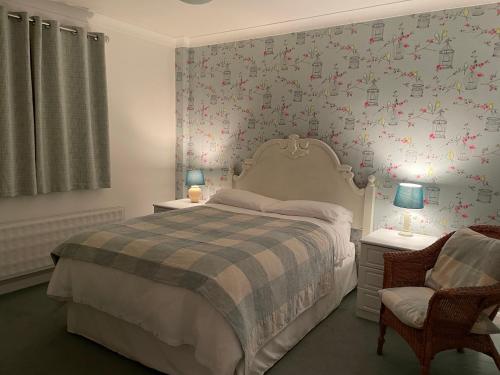 a bedroom with a bed and a wall with flowers at Silver Lodge in Mildenhall