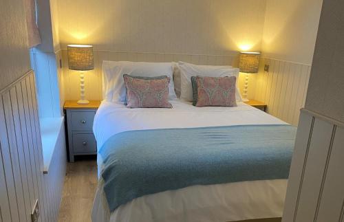 a bedroom with a large white bed with two pillows at Hillview Cottage in Edinburgh
