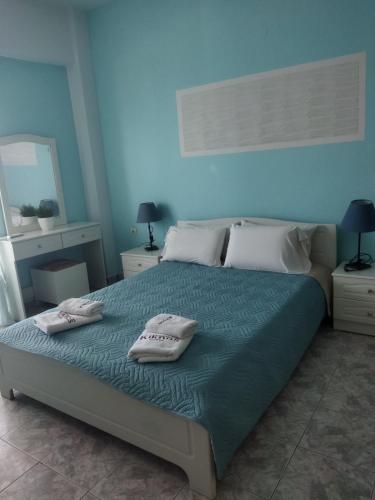 a bedroom with a bed with two towels on it at Kiknos Studios in Kalamaki Heraklion