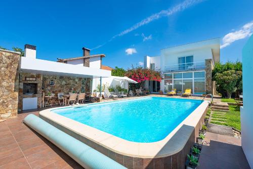 a swimming pool in front of a house at Casa da Magnólia in Murtosa