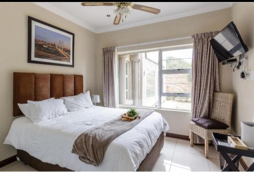 a bedroom with a large bed and a window at Jewel of Jozi in Edenvale