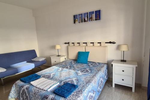 - une chambre avec un lit bleu et un canapé dans l'établissement Vilamoura-Quarteira Beaches Apt with pool and sea view, à Quarteira