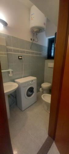 a bathroom with a toilet and a sink and a washing machine at Casa Anna in Gioiosa Marea