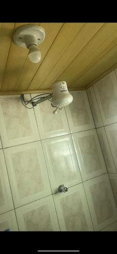 un plafond avec une lumière sur un sol en carrelage blanc dans l'établissement Casa em Diamantina, à Diamantina