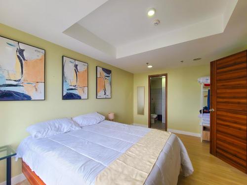 um quarto com uma cama grande com três fotografias na parede em Suite 1 Bedroom with Seaview-Horizons 101 em Cebu