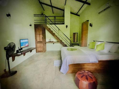 ORENDA ECO LODGE & SPA في غالي: غرفة نوم كبيرة بسريرين ودرج