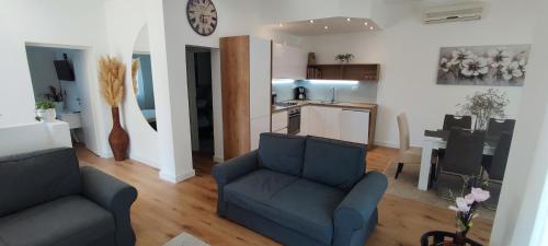 a living room with two couches and a kitchen at Apartman Vlatka in Kninsko Polje