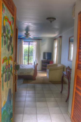 a living room with a couch and a bed and a room with at Gingerbread Restaurant & Hotel in Nuevo Arenal