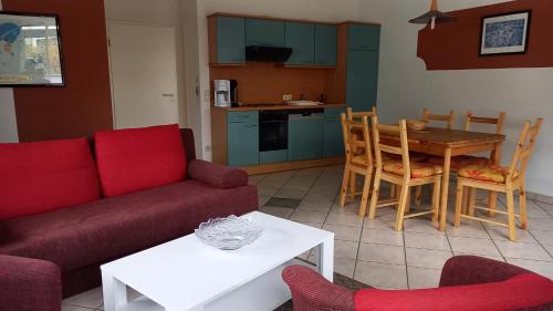 a living room with a couch and a table with chairs at Bernsteinhaus Düne 10 in Zingst