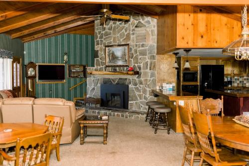 una gran sala de estar con chimenea de piedra. en Redican's Retreat - Great lake view home located near the falls, en Bass Lake