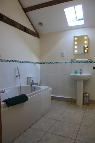 a bathroom with a bath tub and a sink at The Granary Self Catering Cottage in Shrewsbury