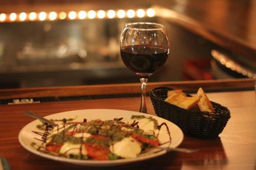 a plate of food and a glass of wine on a table at Gingerbread Restaurant & Hotel in Nuevo Arenal