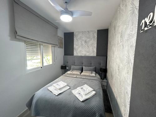 a bedroom with a bed with two towels on it at Gandia Playa Apartamento Elizabeth con vistas al mar in Gandía