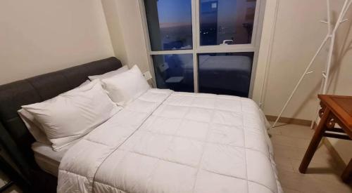 a bedroom with a large white bed with a window at Residential Resort Condo by the Bay in Manila