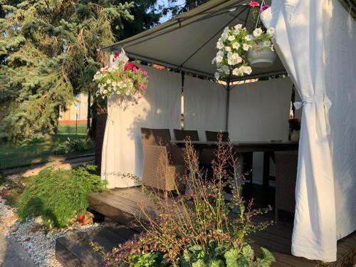 a porch with an umbrella and a bench and flowers at Penzion Bystrica in Považská Bystrica