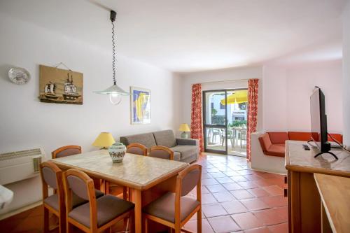 a living room with a table and a couch at Balaia Golf Village in Albufeira