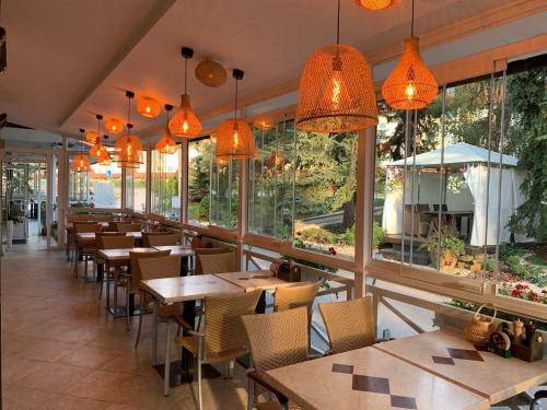 a restaurant with tables and chairs and windows at Penzion Bystrica in Považská Bystrica
