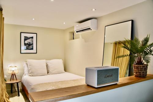 1 dormitorio con 1 cama con espejo y TV en Franca St Jean, en Saint-Jean