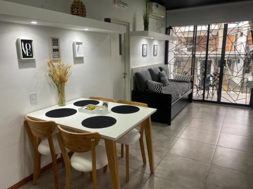 a kitchen with a table and chairs and a living room at DEPARTAMENTO VERA MUJICA 4 COHERA PROPIA INCLUIDA in Rosario