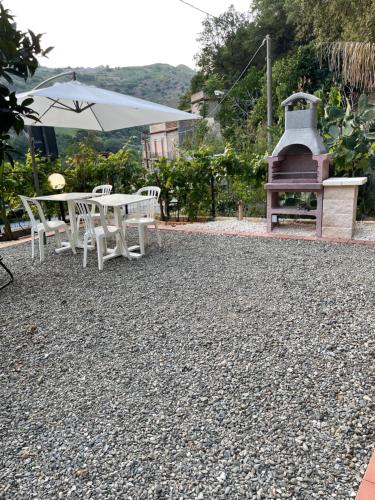 a patio with a table and chairs and a fireplace at Le Maioliche in Saponara Villafranca