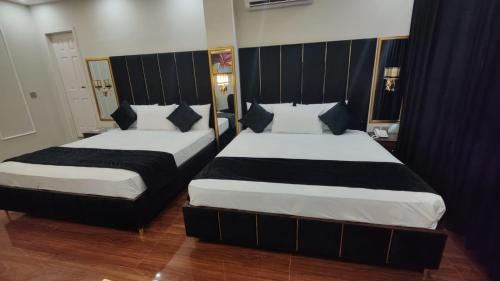 two beds in a hotel room withskirts at Hotel white season Gulberg in Lahore