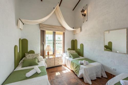 sypialnia z 2 łóżkami i lustrem w obiekcie Casa Rural Olavide 