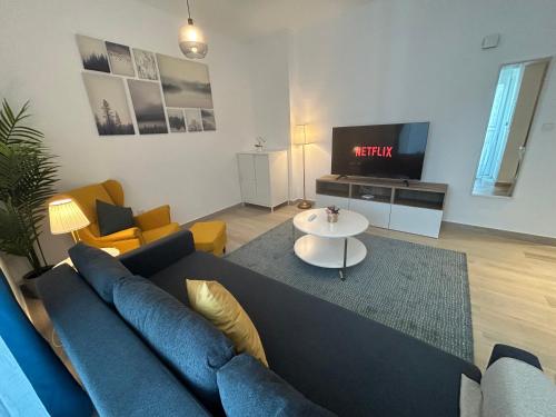 a living room with a blue couch and a tv at The Hive at Yas Island in Abu Dhabi
