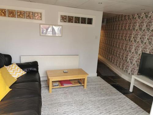 a living room with a couch and a coffee table at Private garden apartment with secure parking in Southport