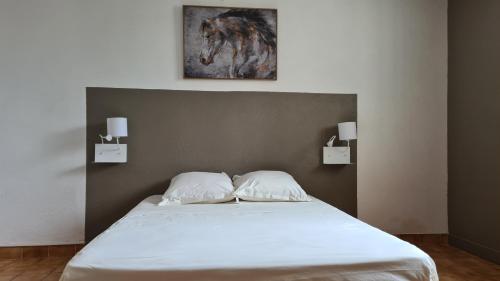 ein Bett mit zwei Kissen darauf in einem Schlafzimmer in der Unterkunft Bas de villa T3 Ollioules avec Piscine Vue mer in Ollioules