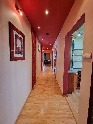 a hallway with red walls and wooden floors at Darłowska 49A in Dąbki