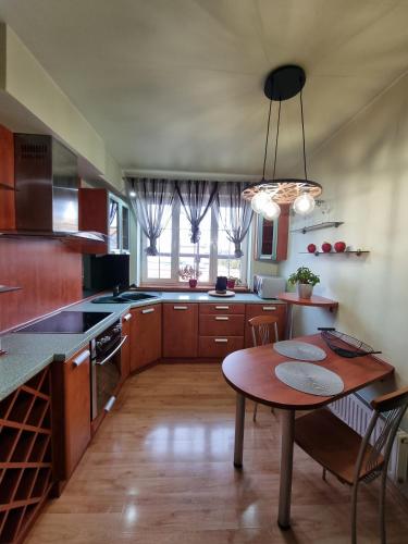 a kitchen with a wooden table and a dining room at Darłowska 49A in Dąbki