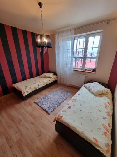 a bedroom with two beds and a striped wall at Darłowska 49A in Dąbki