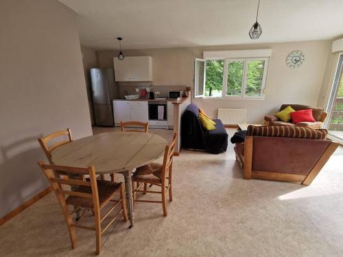 un salon avec une table, des chaises et un canapé dans l'établissement Maisonnette de campagne, à Gerville