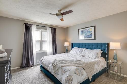 a bedroom with a blue bed and a ceiling fan at Charming Omaha Vacation Rental 1 Mi to Downtown! in Omaha