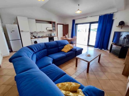 um sofá azul numa sala de estar com uma cozinha em Incantevole attico con grande terrazza em Anzio